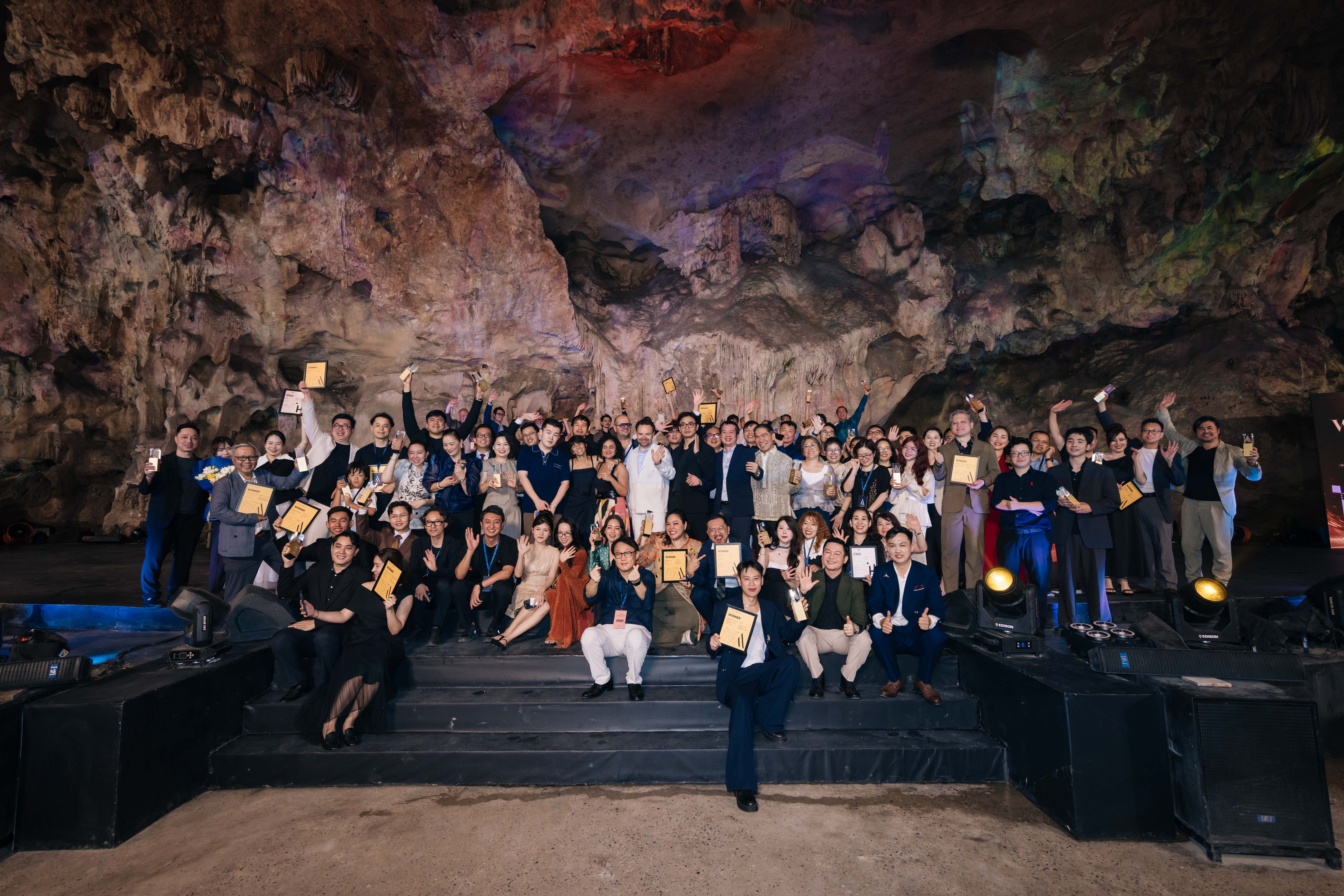 Winners gather on stage inside a cave venue at an Asia Awards Organization Winners' Night.