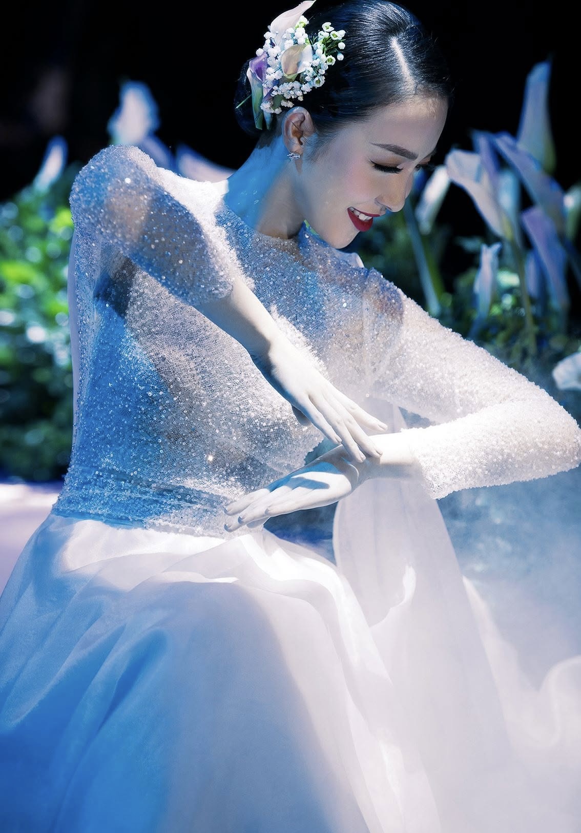 Linh Nga dancing in a sparkling pale gown under stage light