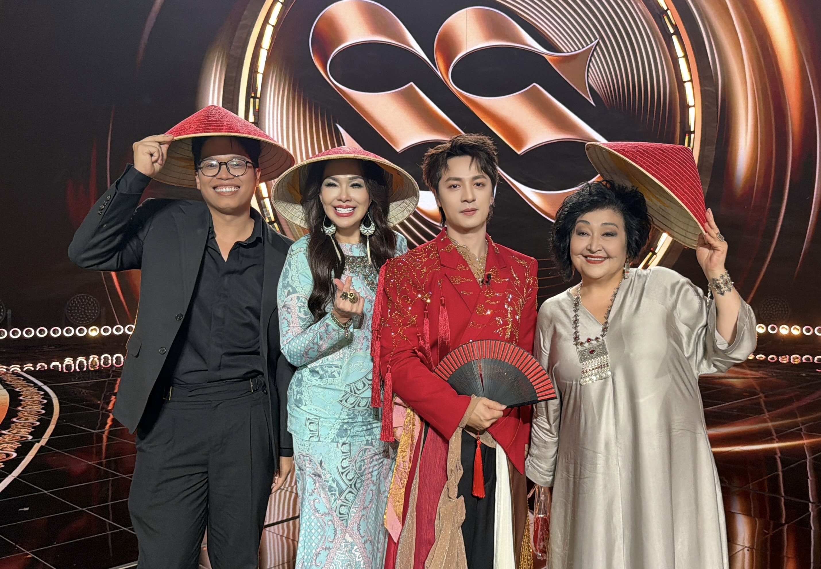 Đăng Khôi in red with three judges, all wearing Vietnamese conical hats, on the Silk Way Star stage.