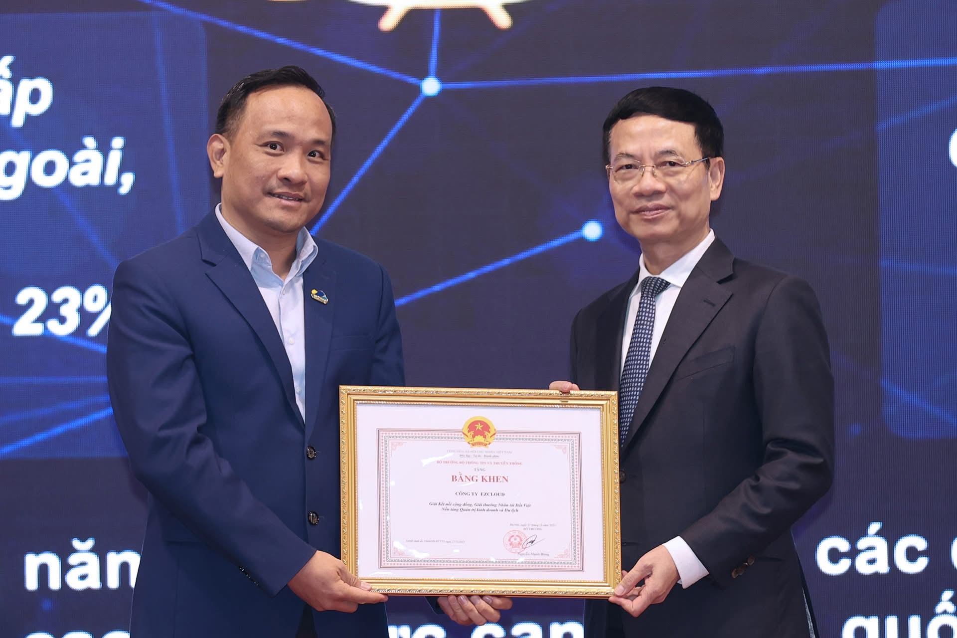 Nguyen Hoang Duong holding a framed certificate of merit with a government official