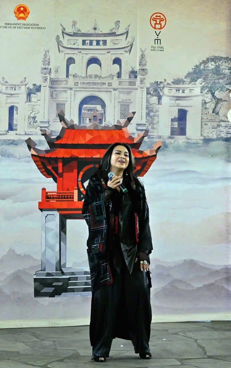 Thanh Lam performing in front of a Temple of Literature backdrop with the UNESCO Vietnam delegation emblem