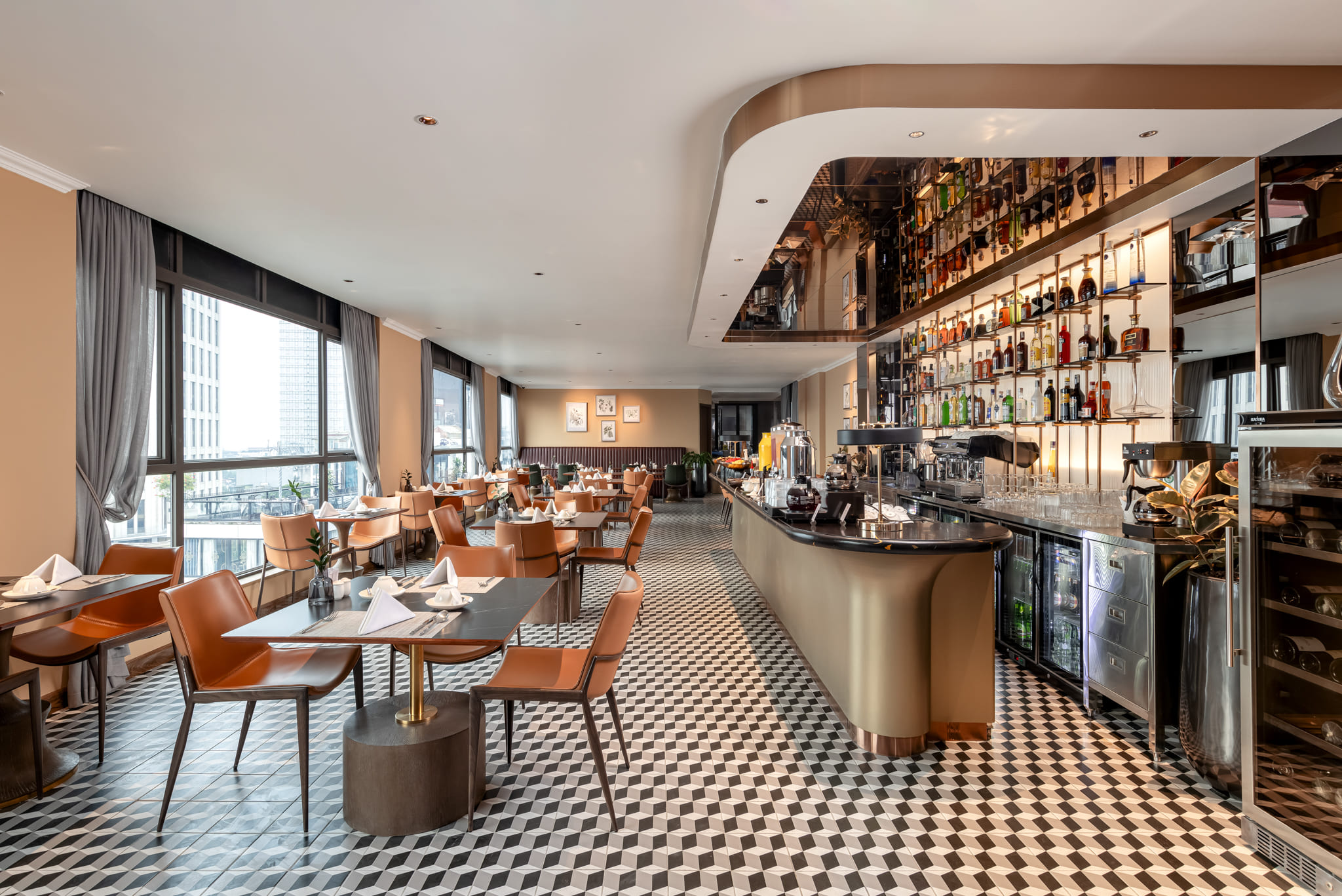 A dining space at La Siesta with leather chairs, marble-top tables and large windows