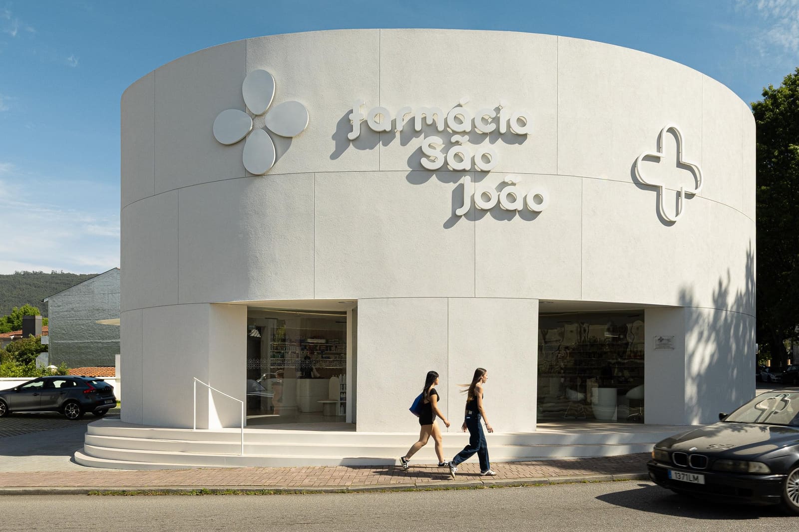 How a Curved Façade Transforms a Corner Pharmacy Into Civic Presence