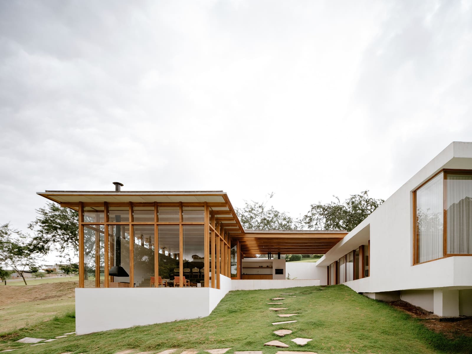 How Engineered Wood and Split-Level Massing Frame a Forest Edge in São Paulo